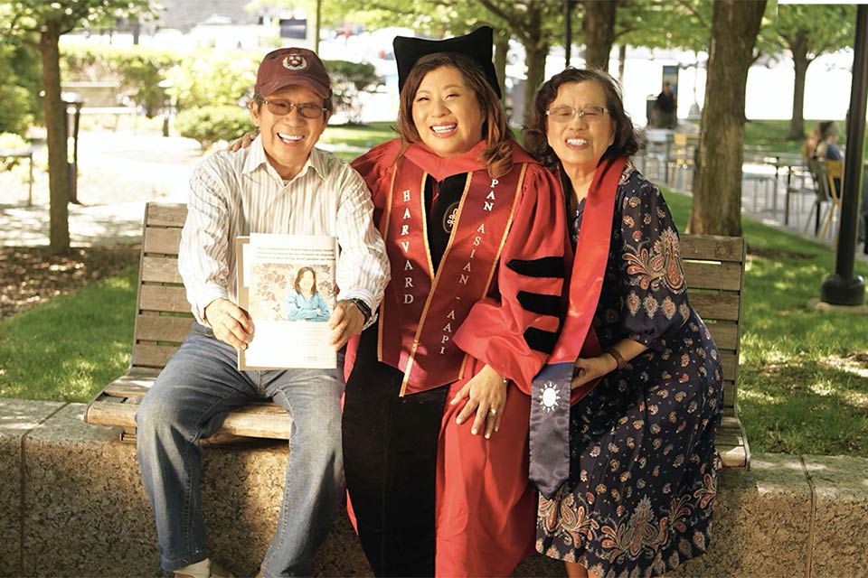 Sarah with parents, Sarah wearing graduation gown